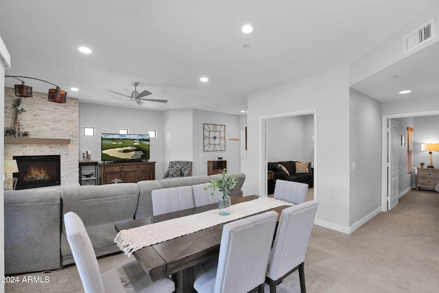 dining area featuring recessed lighting, light colored carpet, visible vents, a stone fireplace, and baseboards