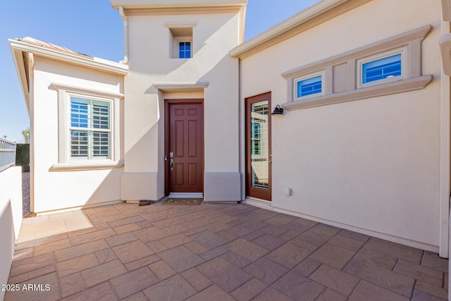 doorway to property featuring a patio and stucco siding