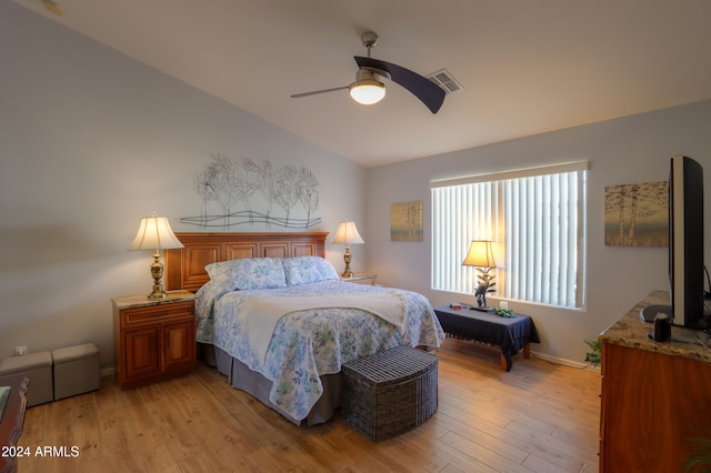 bedroom featuring ceiling fan, light hardwood / wood-style floors, and vaulted ceiling