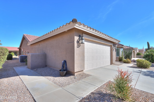 view of property exterior featuring central AC and a garage