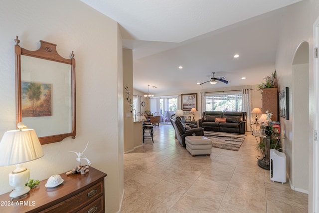 living room featuring light tile patterned floors and ceiling fan with notable chandelier