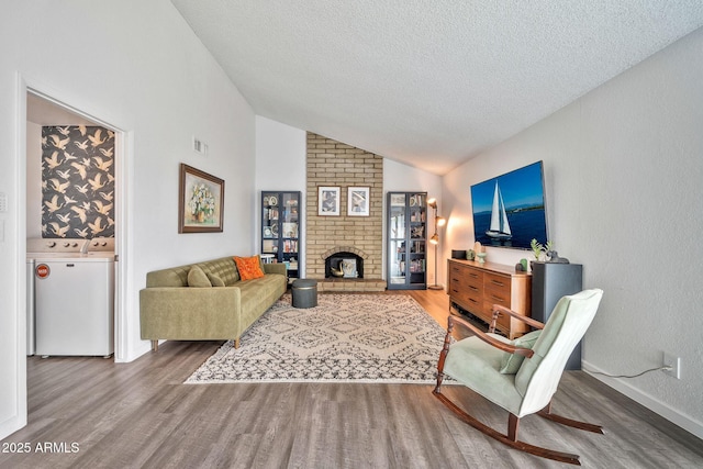 living area with visible vents, washer and dryer, wood finished floors, and vaulted ceiling