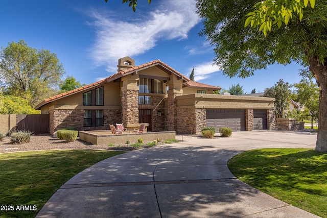 view of front facade featuring an attached garage, fence, stone siding, driveway, and stucco siding