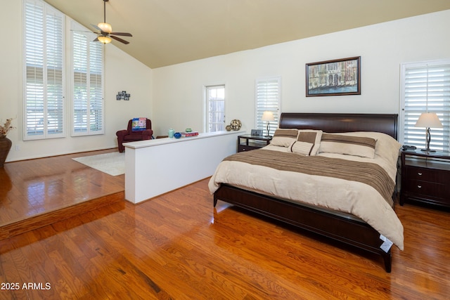 bedroom featuring lofted ceiling, multiple windows, and wood finished floors