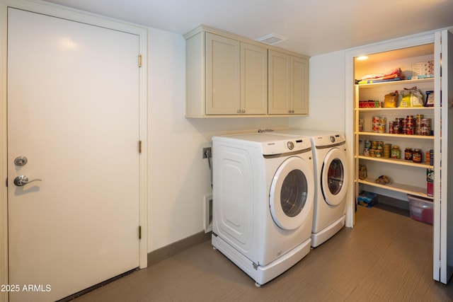 clothes washing area with washer and dryer, cabinet space, and baseboards