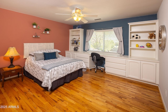 bedroom with a ceiling fan, visible vents, light wood finished floors, and built in study area