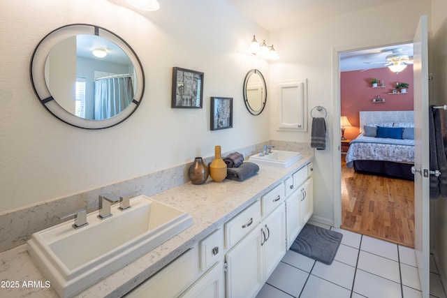 bathroom with connected bathroom, double vanity, a sink, and tile patterned floors