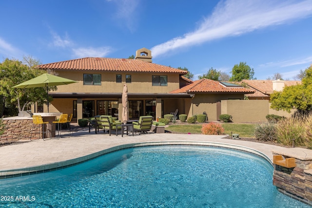 outdoor pool with outdoor dry bar, a patio, an outdoor kitchen, and an outdoor living space