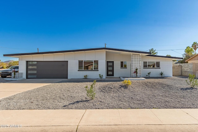 view of front of property with driveway, an attached garage, and fence