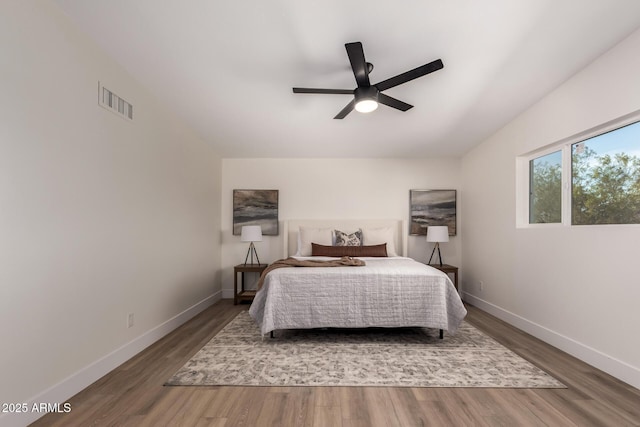 bedroom with visible vents, baseboards, ceiling fan, and wood finished floors
