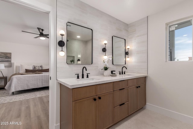 ensuite bathroom with backsplash, a sink, ensuite bath, and ceiling fan
