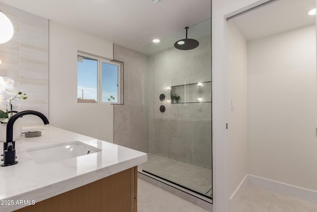 bathroom featuring a sink, tile patterned flooring, walk in shower, baseboards, and double vanity