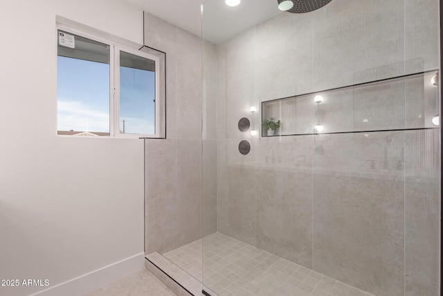 full bathroom featuring baseboards, tiled shower, and tile patterned flooring