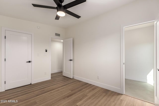 unfurnished bedroom featuring baseboards, light wood-style flooring, visible vents, and ceiling fan