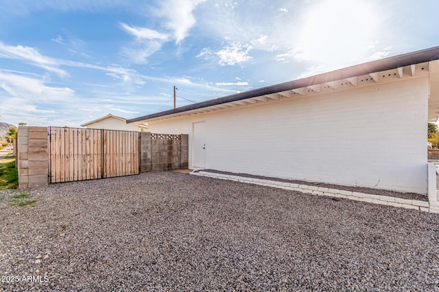 view of home's exterior with a gate and fence