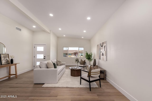 living room featuring baseboards, visible vents, wood finished floors, and recessed lighting