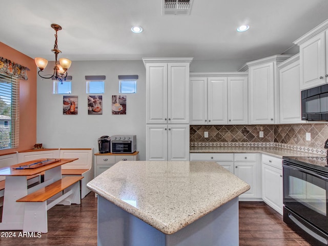 kitchen with white cabinets, black appliances, dark hardwood / wood-style floors, and hanging light fixtures