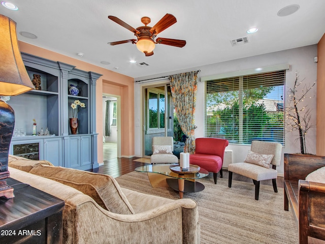 living room featuring light hardwood / wood-style flooring and ceiling fan