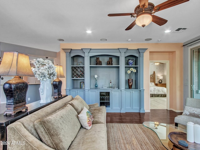 living room with dark hardwood / wood-style floors, ceiling fan, and indoor bar