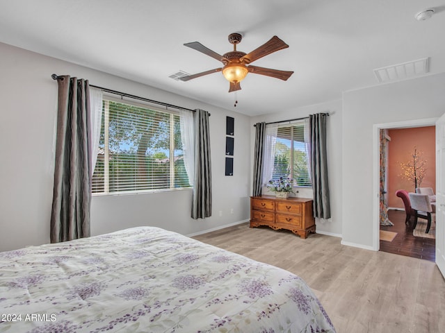 bedroom with multiple windows, ceiling fan, and light hardwood / wood-style flooring