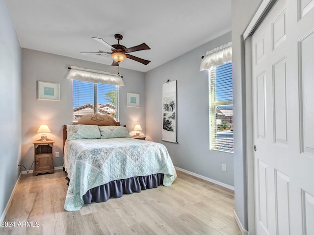 bedroom featuring a closet, light hardwood / wood-style floors, and ceiling fan