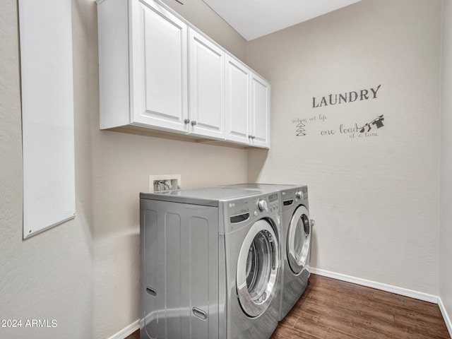 washroom featuring cabinets, dark hardwood / wood-style floors, and washing machine and clothes dryer