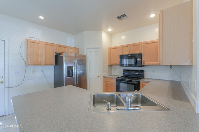 kitchen featuring black appliances, light brown cabinetry, kitchen peninsula, and sink