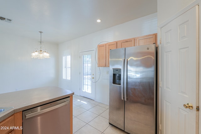 kitchen featuring stainless steel appliances, a notable chandelier, light brown cabinets, light tile patterned flooring, and pendant lighting