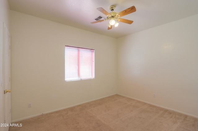 empty room with ceiling fan and light carpet