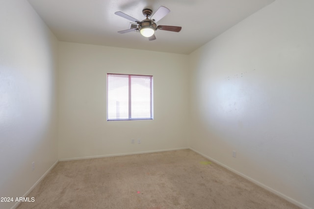 spare room featuring ceiling fan and light carpet