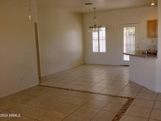 unfurnished dining area with a notable chandelier and light tile patterned flooring