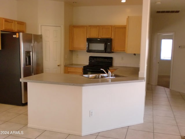 kitchen featuring light brown cabinetry, light tile patterned floors, black appliances, and kitchen peninsula