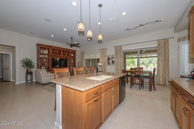 kitchen featuring sink, a center island with sink, pendant lighting, and light tile patterned flooring