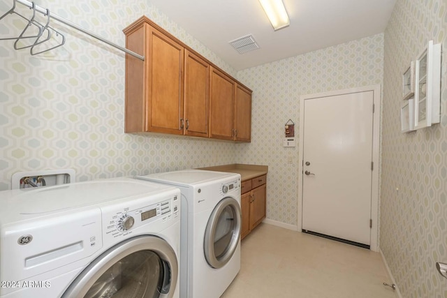 clothes washing area with cabinets and independent washer and dryer