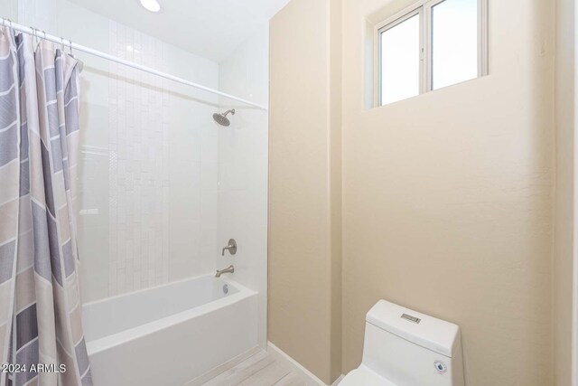 bathroom featuring toilet and shower / tub combo