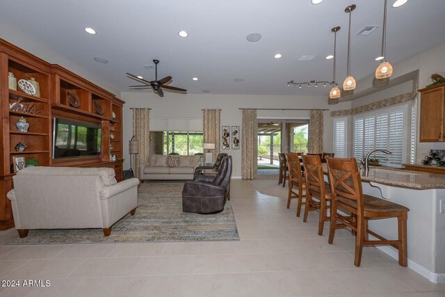 tiled living room with sink and ceiling fan