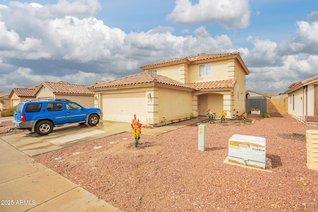 view of front of house featuring stucco siding, driveway, a tile roof, fence, and a garage