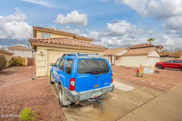 mediterranean / spanish home with a tile roof, concrete driveway, a garage, and stucco siding