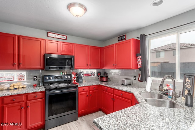 kitchen featuring a sink, tasteful backsplash, reddish brown cabinets, stainless steel electric range, and light stone countertops