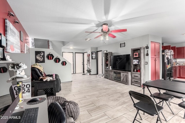 living area with visible vents and ceiling fan