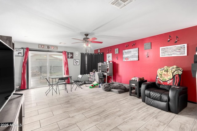 living area featuring visible vents and ceiling fan