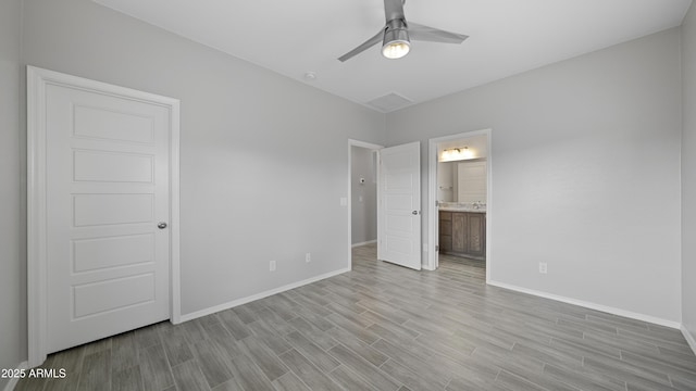 unfurnished bedroom featuring baseboards, light wood-type flooring, ceiling fan, and ensuite bathroom