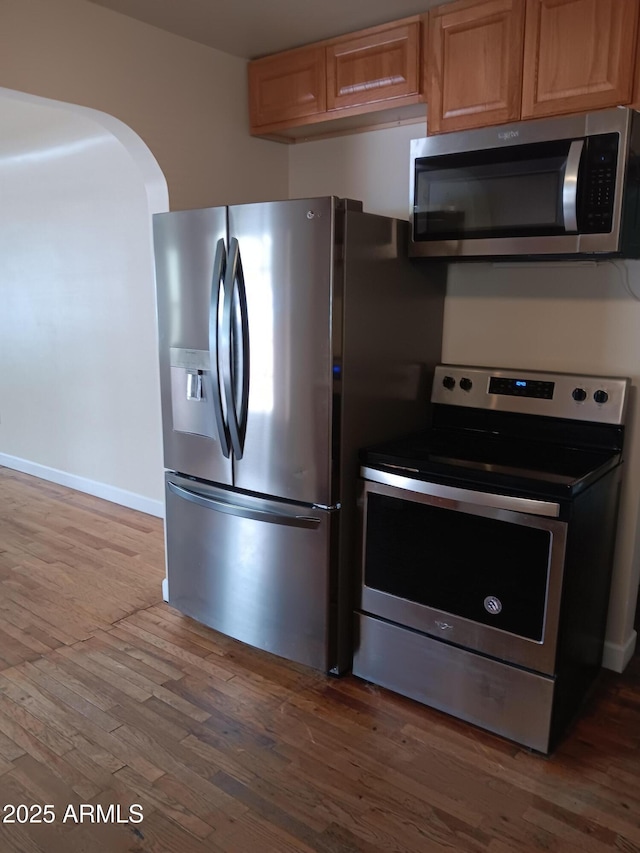 kitchen with hardwood / wood-style floors and stainless steel appliances