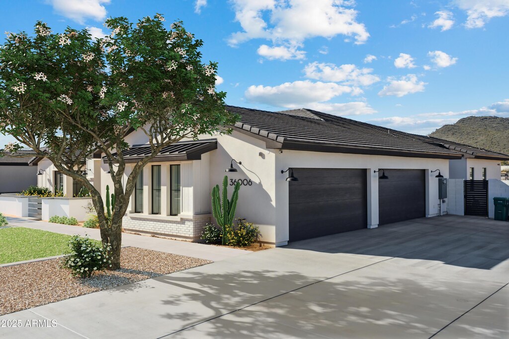 1620 W Butte Canyon Rd, Phoenix, AZ 85086 - view of front facade featuring an attached garage, driveway, brick siding, and stucco siding