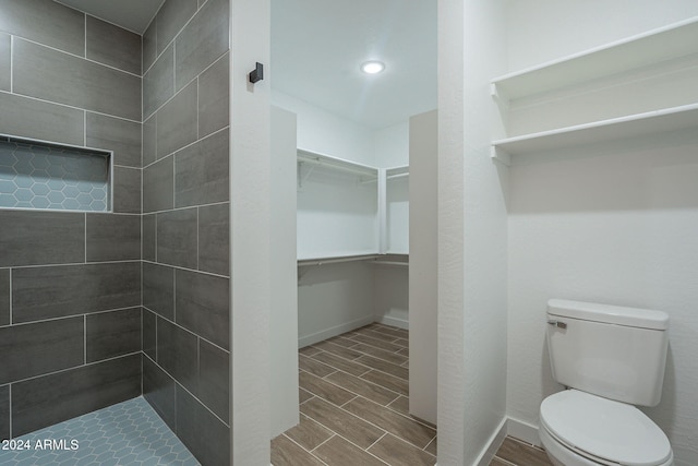 bathroom featuring toilet and a tile shower