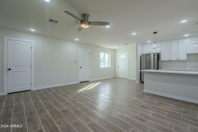 unfurnished living room with wood-type flooring and ceiling fan