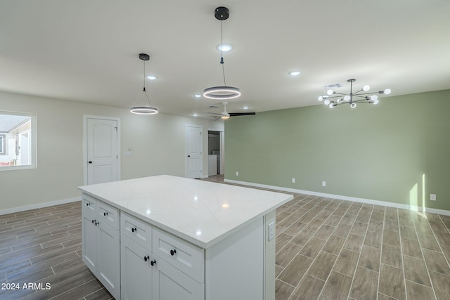 kitchen with white cabinets, pendant lighting, and hardwood / wood-style flooring