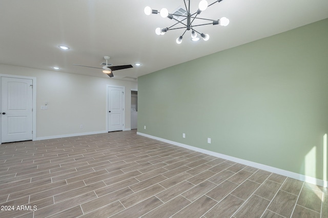 empty room with light hardwood / wood-style floors and ceiling fan with notable chandelier