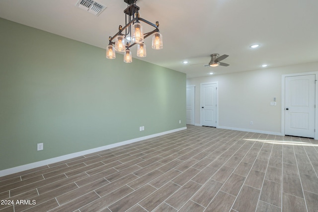 empty room featuring light hardwood / wood-style flooring and ceiling fan with notable chandelier