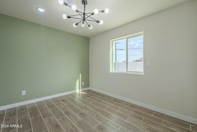 empty room with a chandelier and hardwood / wood-style flooring